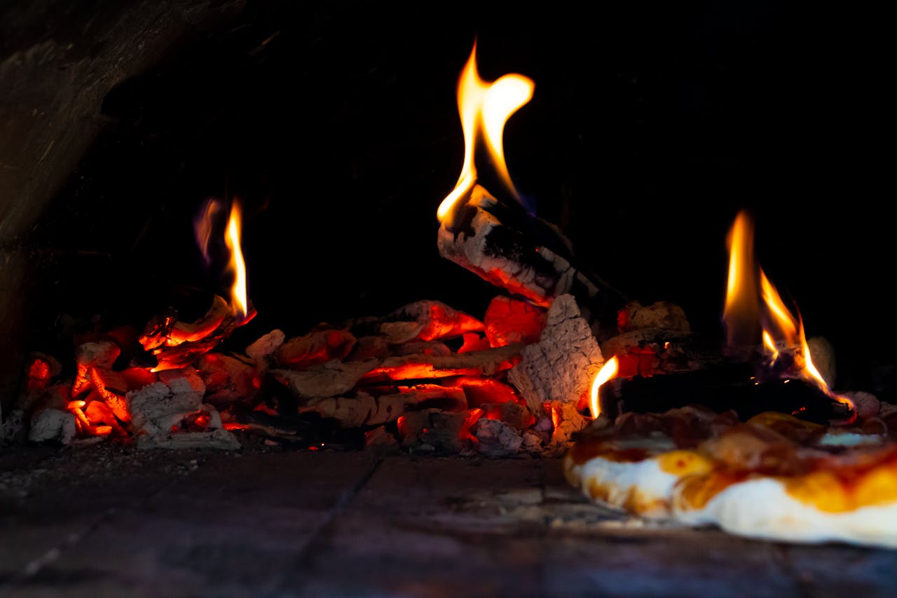 The Art of Drawing Readers In: Your attractive post title goes here A close-up of a stone oven with bright flames, showcasing the baking process of a pizza.