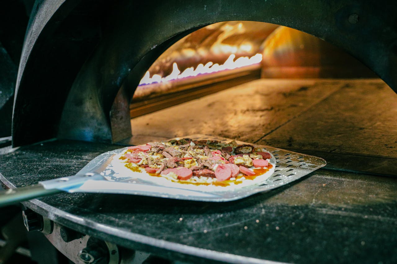 Mastering the First Impression: Your intriguing post title goes here Fresh pizza being prepared in a traditional wood-fired stone oven, capturing authentic Italian cooking.